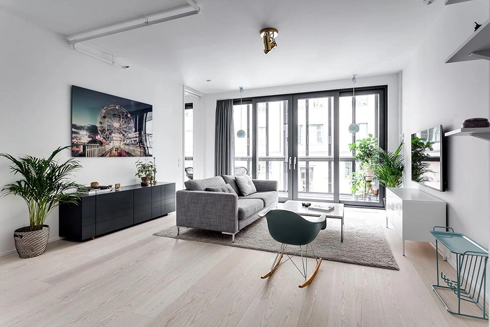 Báo giá thi công nội thất nhà phố phong cách Scandinavian với sàn gỗ sáng màu và nhiều cây xanh.