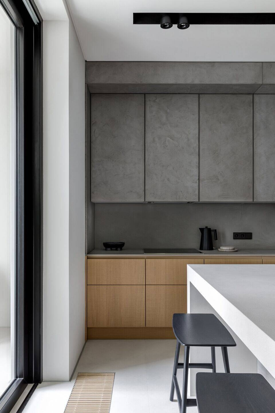 Thiết kế nội thất quận 9 đảo bếp mặt đá trắng và ghế bar gỗ đen.