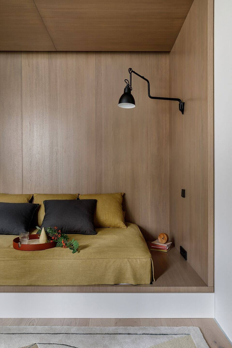 Thiết kế nội thất quận 9 giường hốc tường ốp gỗ sồi ấm cúng và đèn đọc sách.