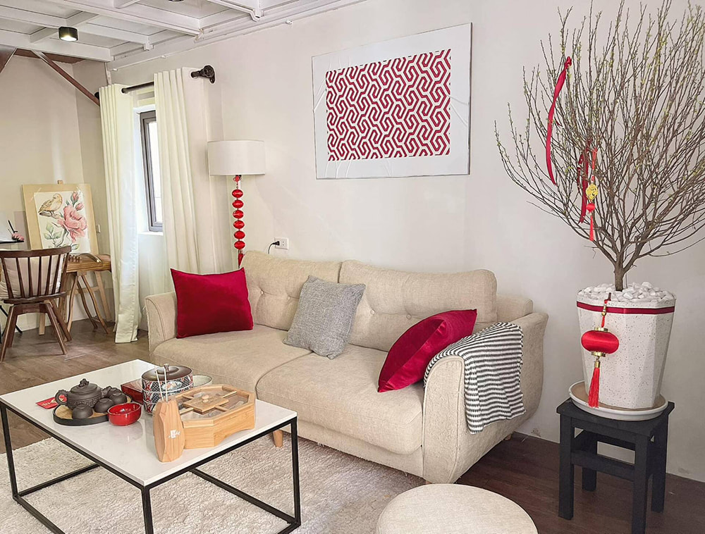 Cây đào dăm lớn nở rộ trang trí phòng khách ngày tết cạnh sofa màu kem