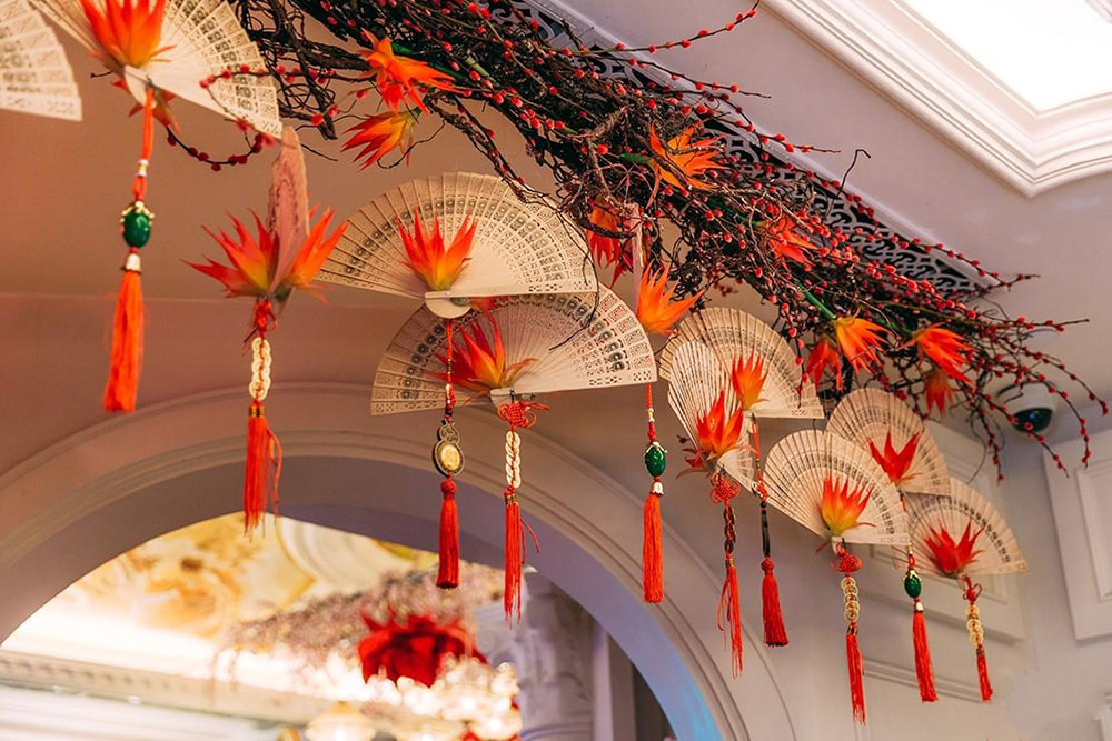 Trang trí văn phòng ngày tết trên trần nhà bằng cành khô và quạt giấy đỏ.