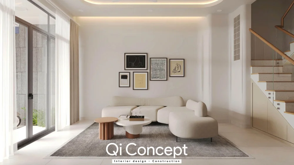 Sofa bo cong cạnh cửa kính, bàn trà tròn và cầu thang ở cuối phòng