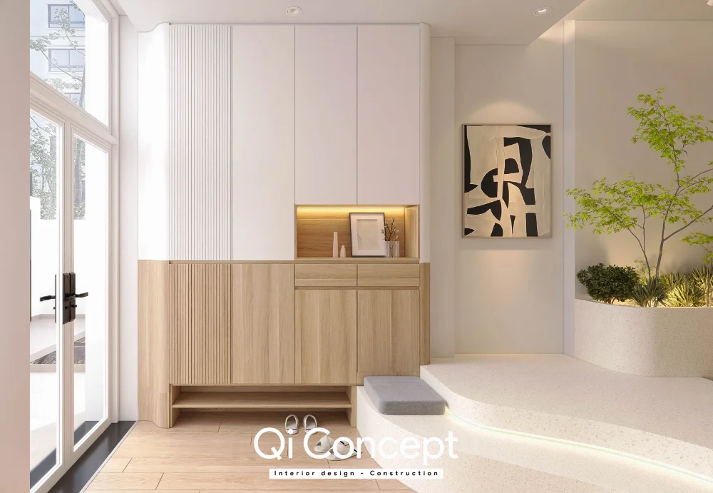 Tủ cao phối trắng và vân gỗ cạnh cửa vào và bồn cây